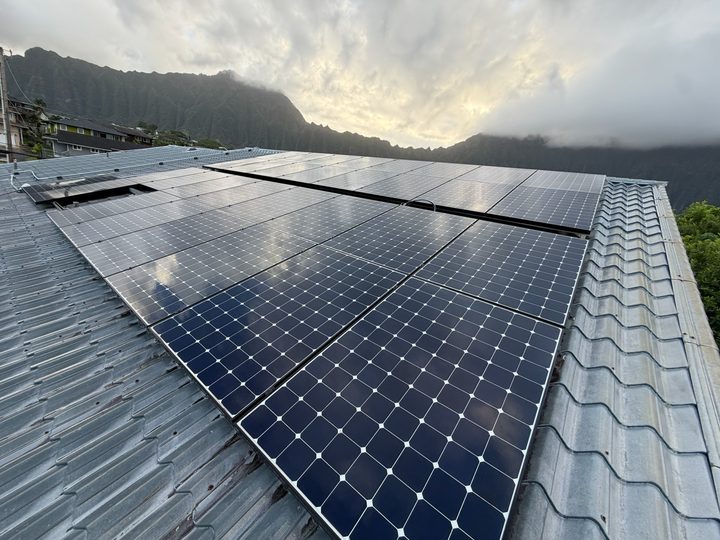 Clean solar array on a metal tile roof under the Koolau mountains