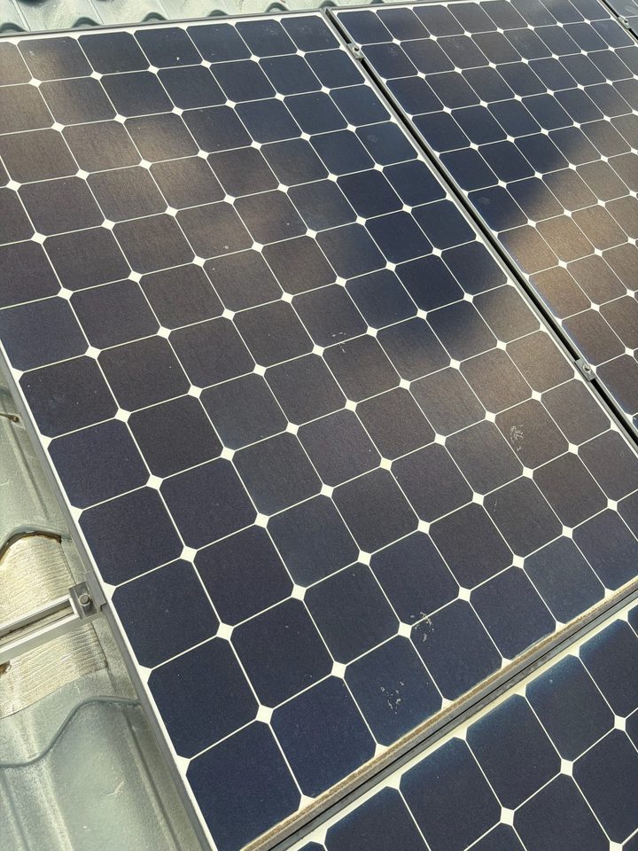 Solar panel glass covered in a hazy film before cleaning