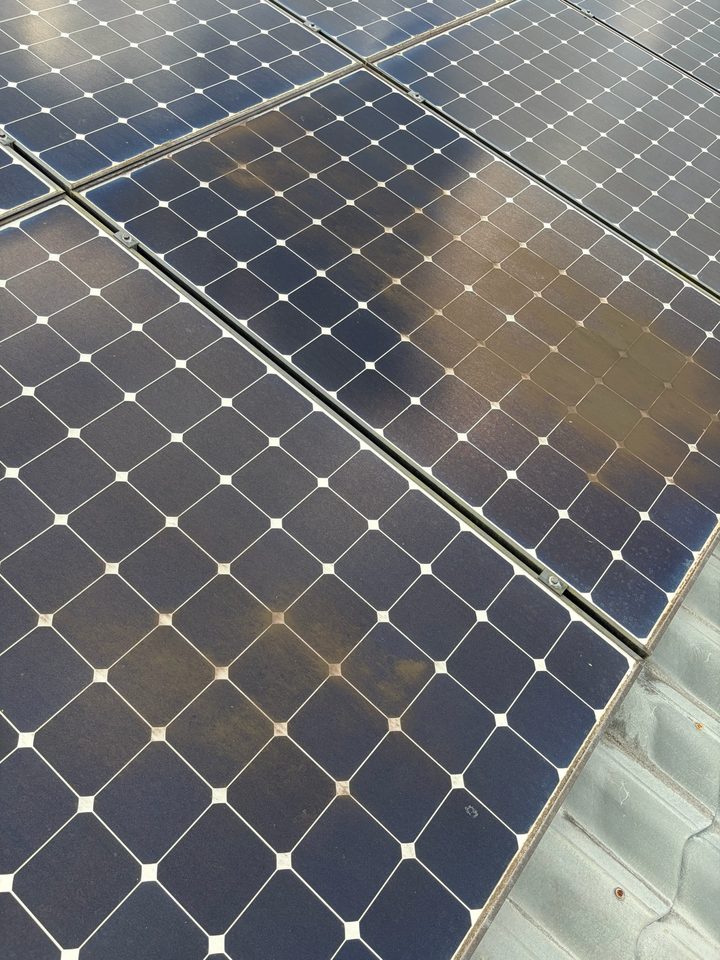 Solar panels with a brown film across the glass before cleaning